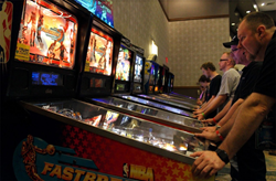A photo of some gentlemen playing pinball