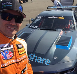 Professional race car driver Andy Lally, founder of ALIVE, poses in MotorCrush racing suit.