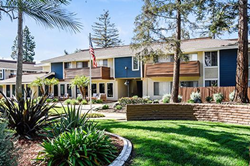 Exterior view of apartments with beautiful green lawn and landscaped areas.