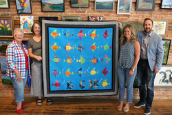 Pictured left to right: Mrs. Martha Besecker, Ms. Andi Finch (The Foundry), Ms. Erika Besecker (Ben Chambers 3rd grade), Mr. Dennis Little (ReliAvail I.T. Company) pose with the quilt at The Foundry’s Chambersburg gallery