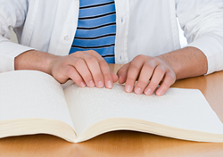 Student reading braille textbook