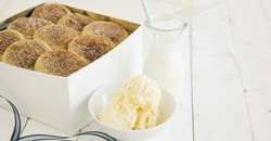 Photo shows an open box of Tiff's Treats' snickerdoodle cookies alongside a glass of milk and a bowl of ice cream.