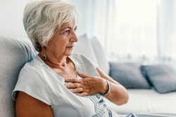 older woman clutching her chest