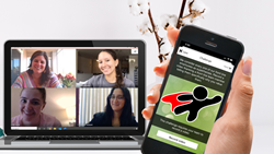 Hand holding phone with custom app with laptop screen web conference