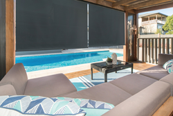 outdoor shades pulled down on patio with furniture and pool