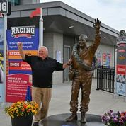 Four-time Indy 500 winner A.J. Foyt poses alongside his likeness at The Children's Museum of Indianapolis.