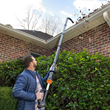 Gutterpro attachment blows leaves and other debris from gutters while user stands safely on ground.