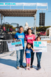 A mixed race family poses with signs that read "Not One More Shattered Dream" in front of The Big PUSH main stage