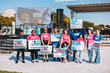 A group of maternal/infant health advocates in pink and blue shirts hold signs in front of the Big PUSH main stage.