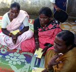 Three SKS clients receiving their microcredit loan books