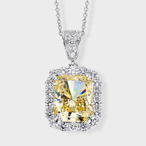 3.5 carat radiant cut simulated yellow diamond surrounded by prong set round stones; approximate 4.34 total carat weight, set in 14k white gold.