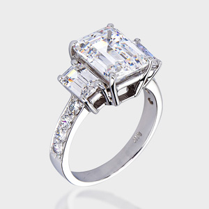 This gorgeous high quality cubic zirconia ring features a 3.0 carat classic emerald-cut center with 0.50 carat emerald-cut stone on each side, accented with round stones pave-set on the band.