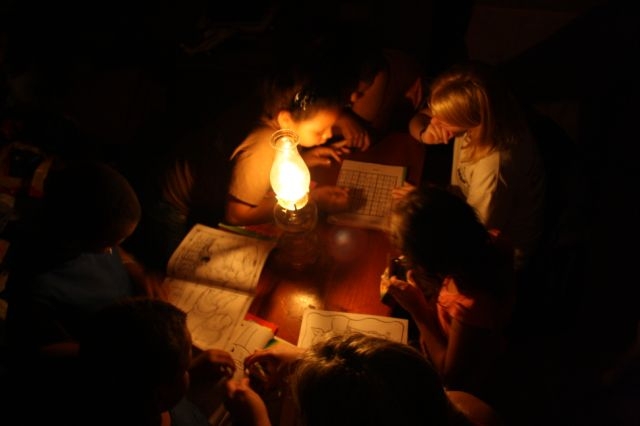 children trying to study by kerosene light