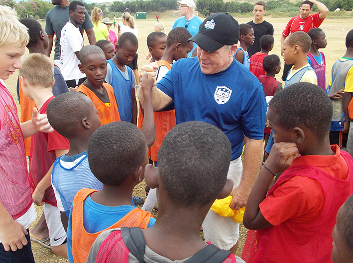 Kicking Coach Tom Feely Surrounded by Young Haitian Athletes