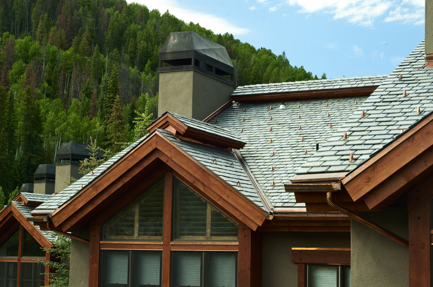 DaVinci polymer roofing tiles with blue in the color blend mixture complements this mountain setting.