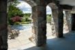 Stone arched pass-through to jacuzzi and pool area.