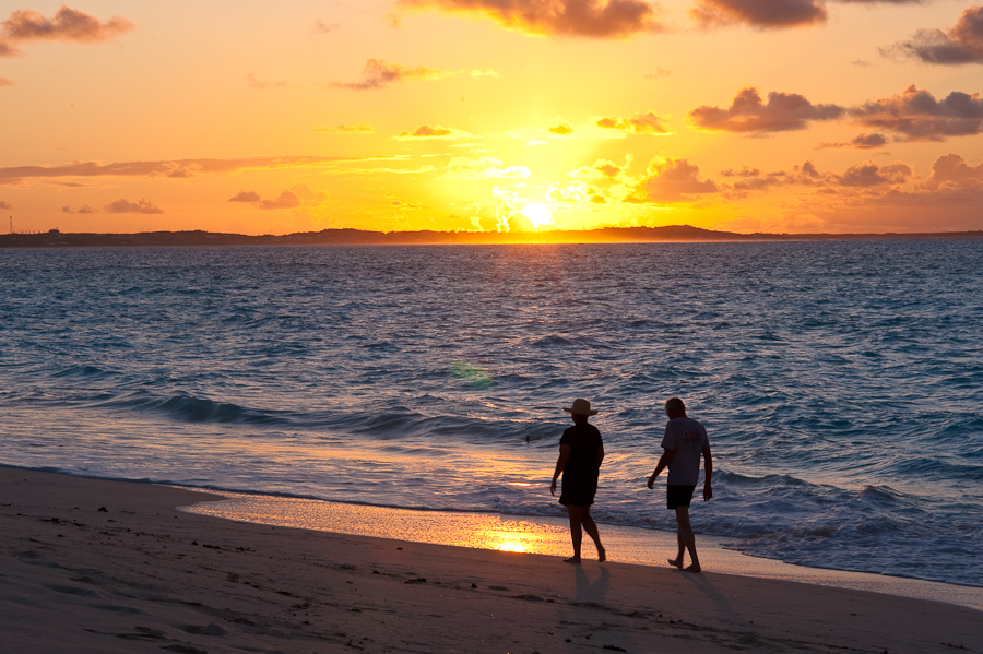 Couples enjoy walks on Grace Bay Beach at sunset.
