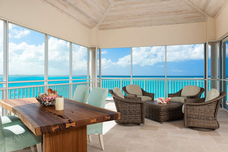 Screened in porch in The Venetian Penthouse Suite offers incredible views of Grace Bay Beach.