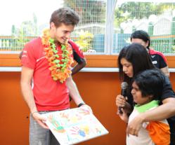 Marussia F1 Team Driver, Jules Bianchi, receives handprint art made by a child at the Taarana School