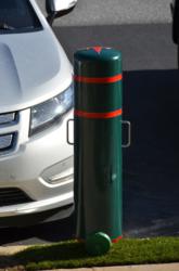 A Reliance Foundry plastic post cover that has been modified into an electric car charging station is shown at the edge of a parking space