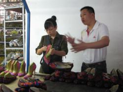 Winnie inspects high heel shoes at shoe factory in China