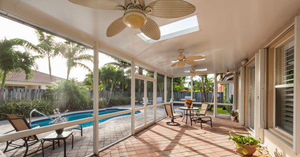 A screened patio cover by Venetian Builders, Inc., Miami. The roof panels carry power to fans and lights.