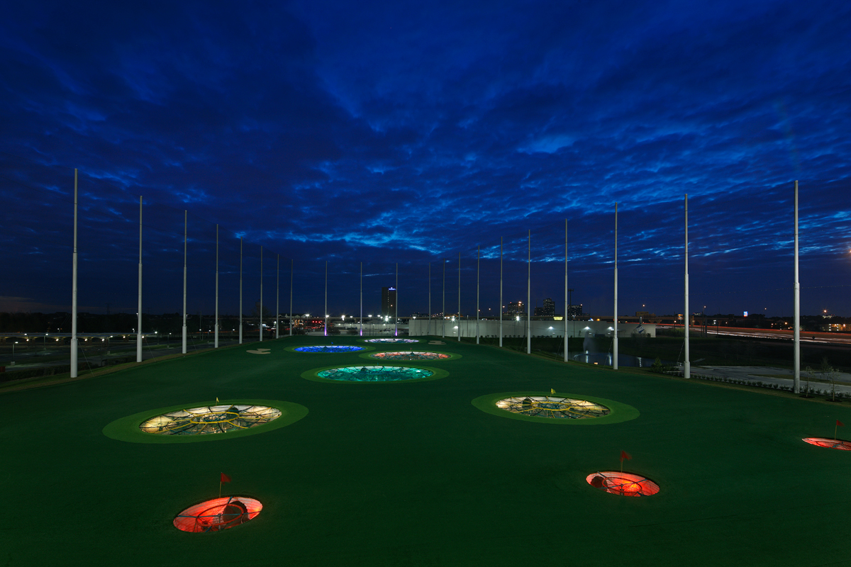 TopGolf outfield with targets lit up at night for point-scoring golf games