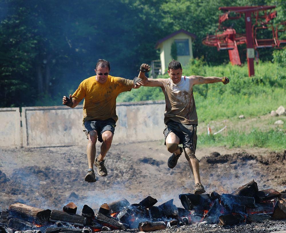 The finish of the race involved climbing over an 8 foot wall and then jumping over a fire pit. Dr. Michael Cocilovo is on the right.