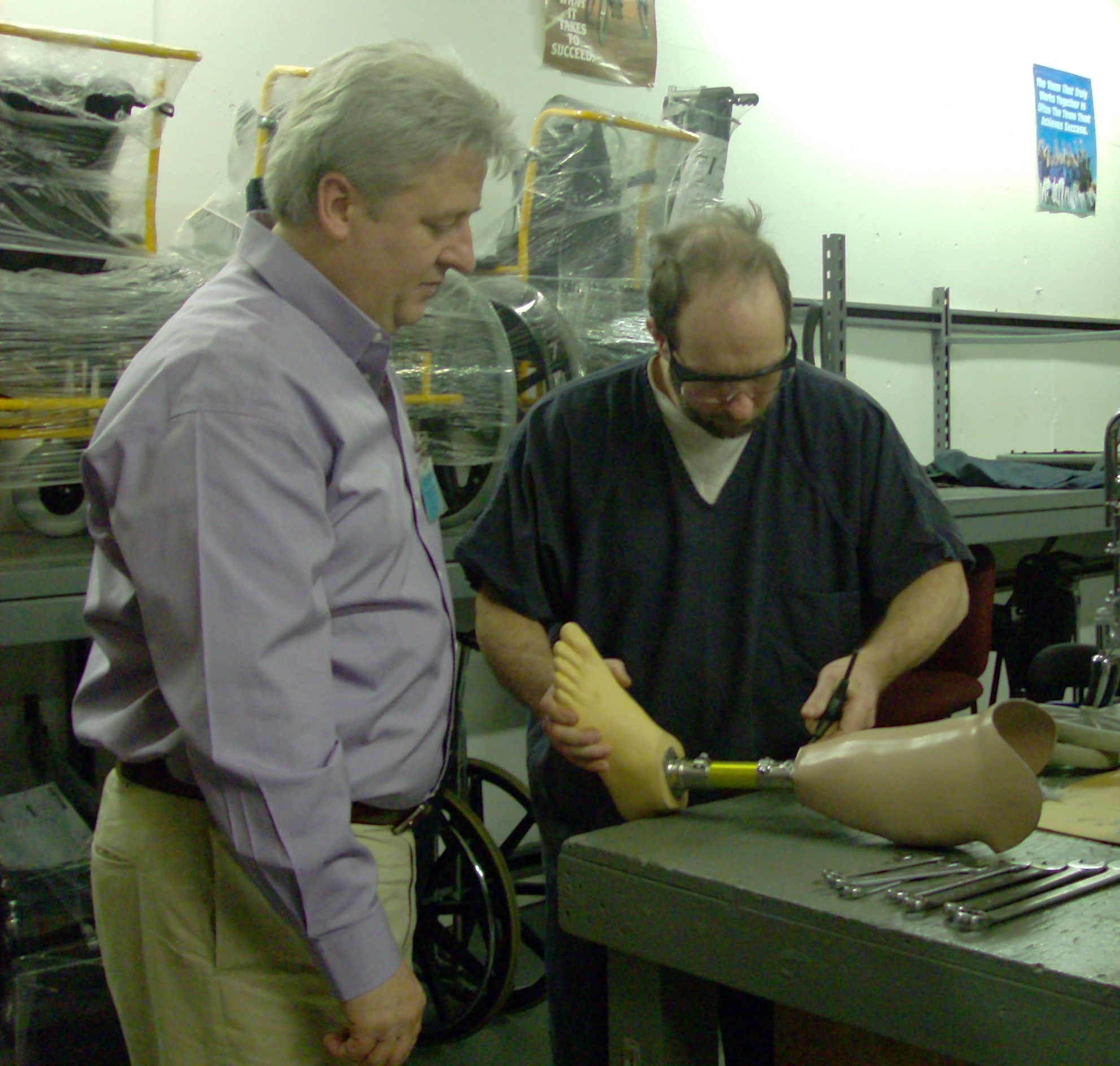 SWH President Peter Rosenberger instructing an inmate on how to disassemble a used prosthetic leg.