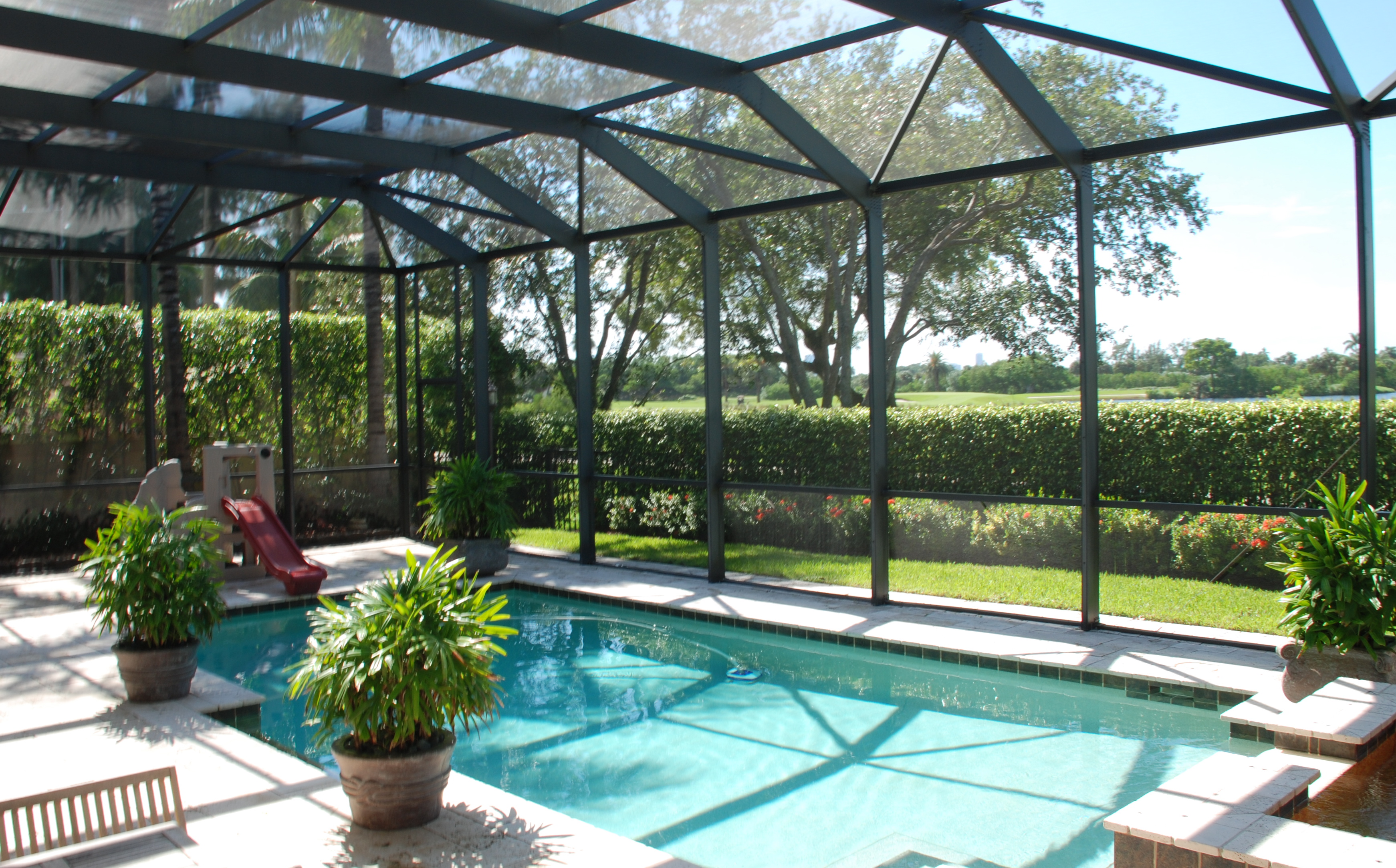 A screen pool enclosure from Venetian Builders, Inc., Miami. Heavier-gauge framing looks elegant look but adds strength.