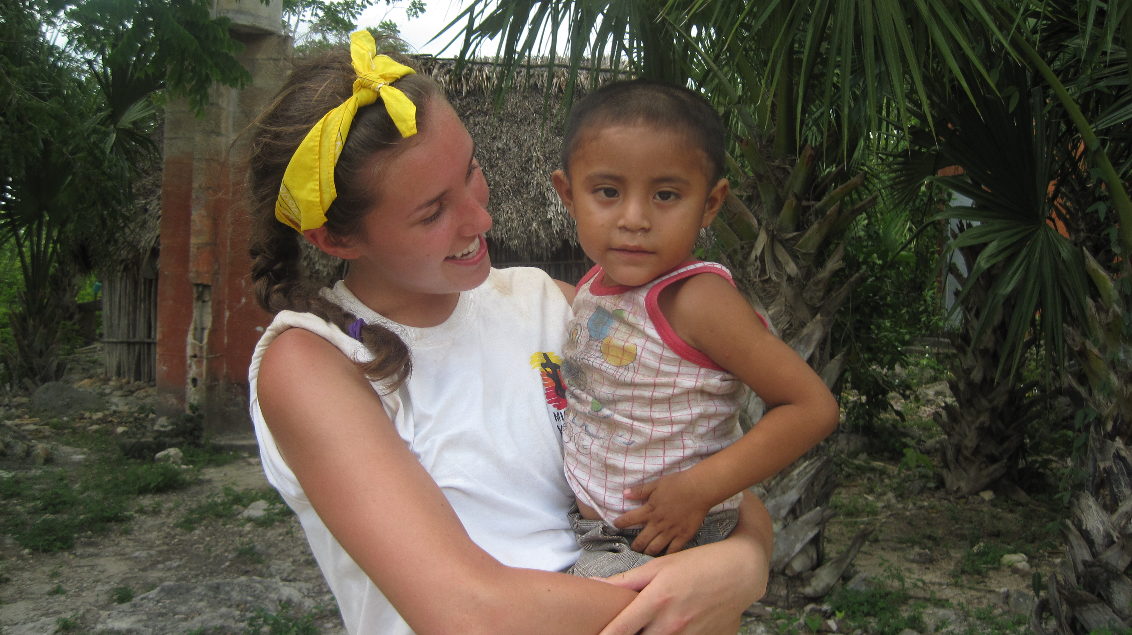 Gabby Diamond, a graduate of Everest Academy, holds a young child from Nuevo Druango