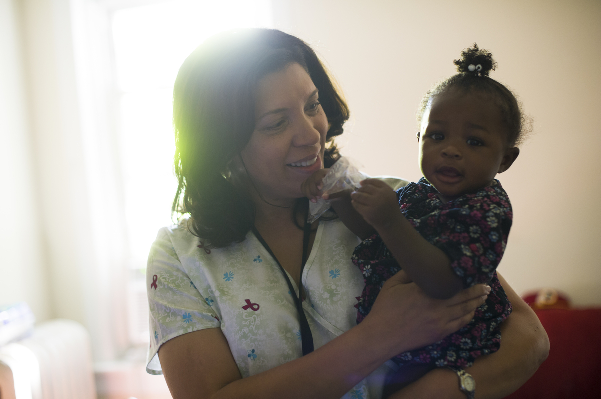 Public health nurse examines young child