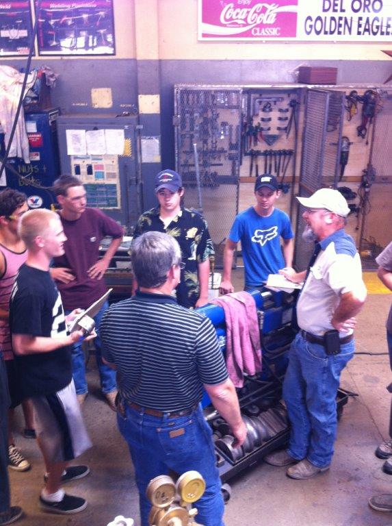 Bill Wenzel (R) explains welding certification to high school students.