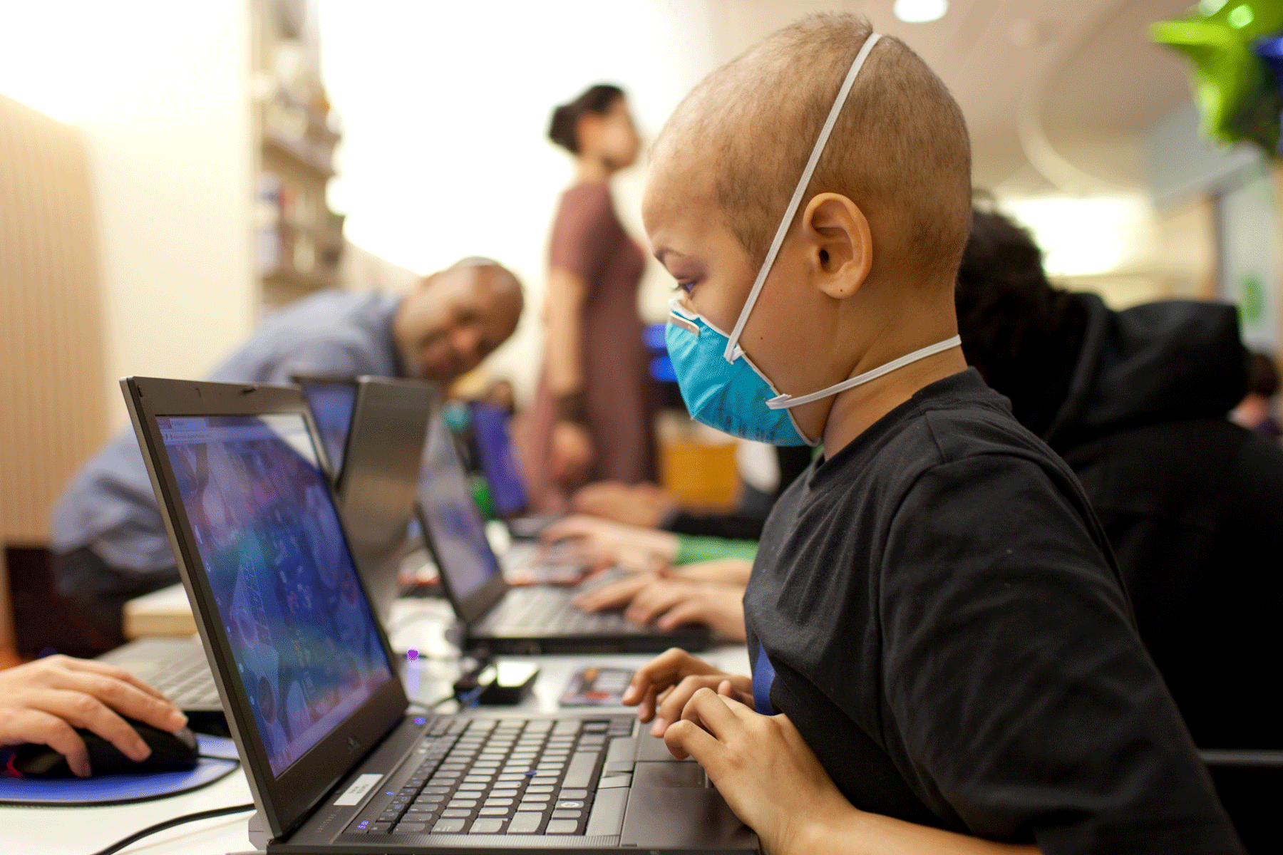 A young cancer patient plays Re-Mission 2 games in hospital waiting room.