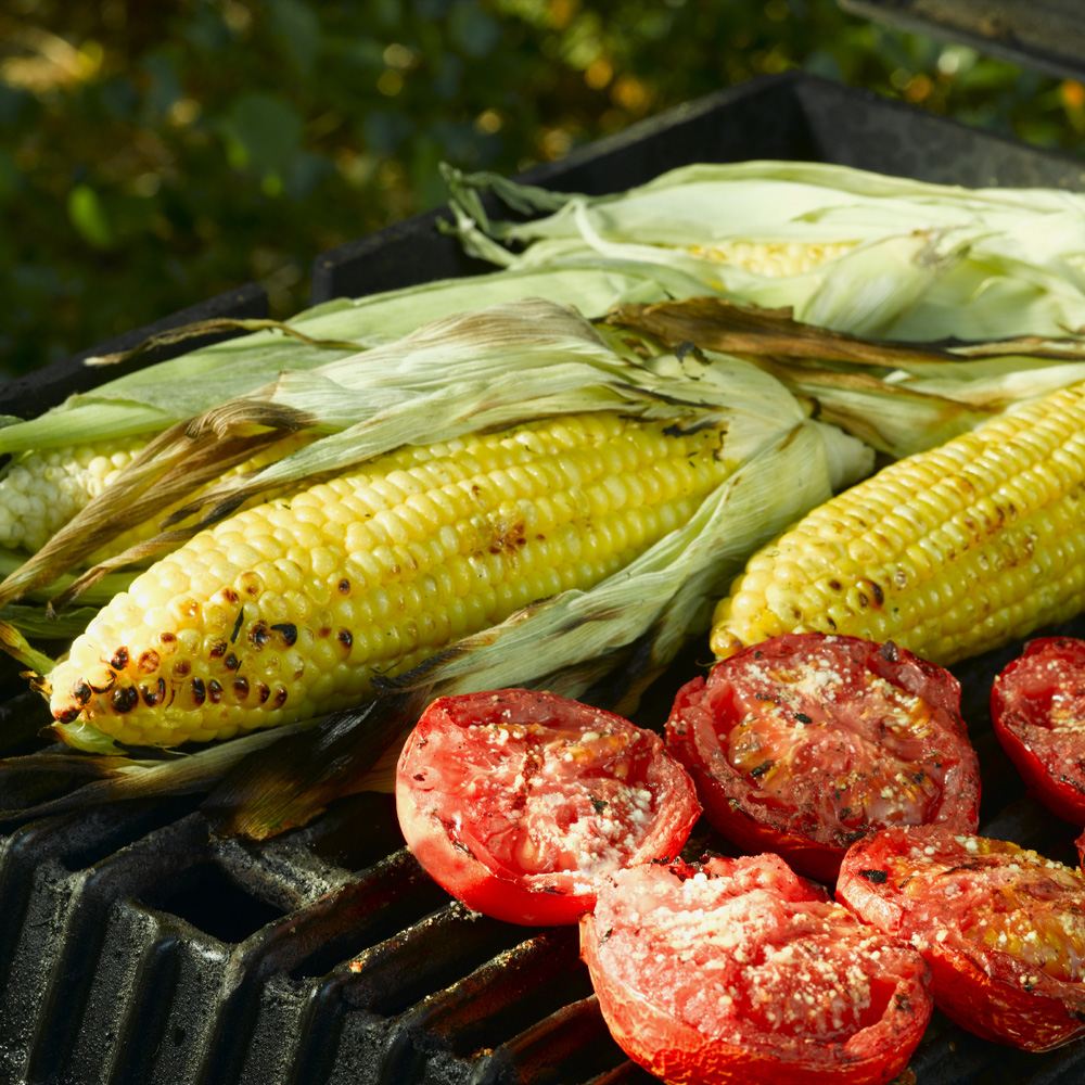 Corn with Herbal Magic seasonings roasting on the grill.
