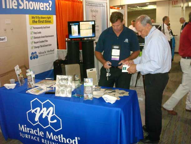 Matt Mozingo of Miracle Method shows color samples to a booth visitor