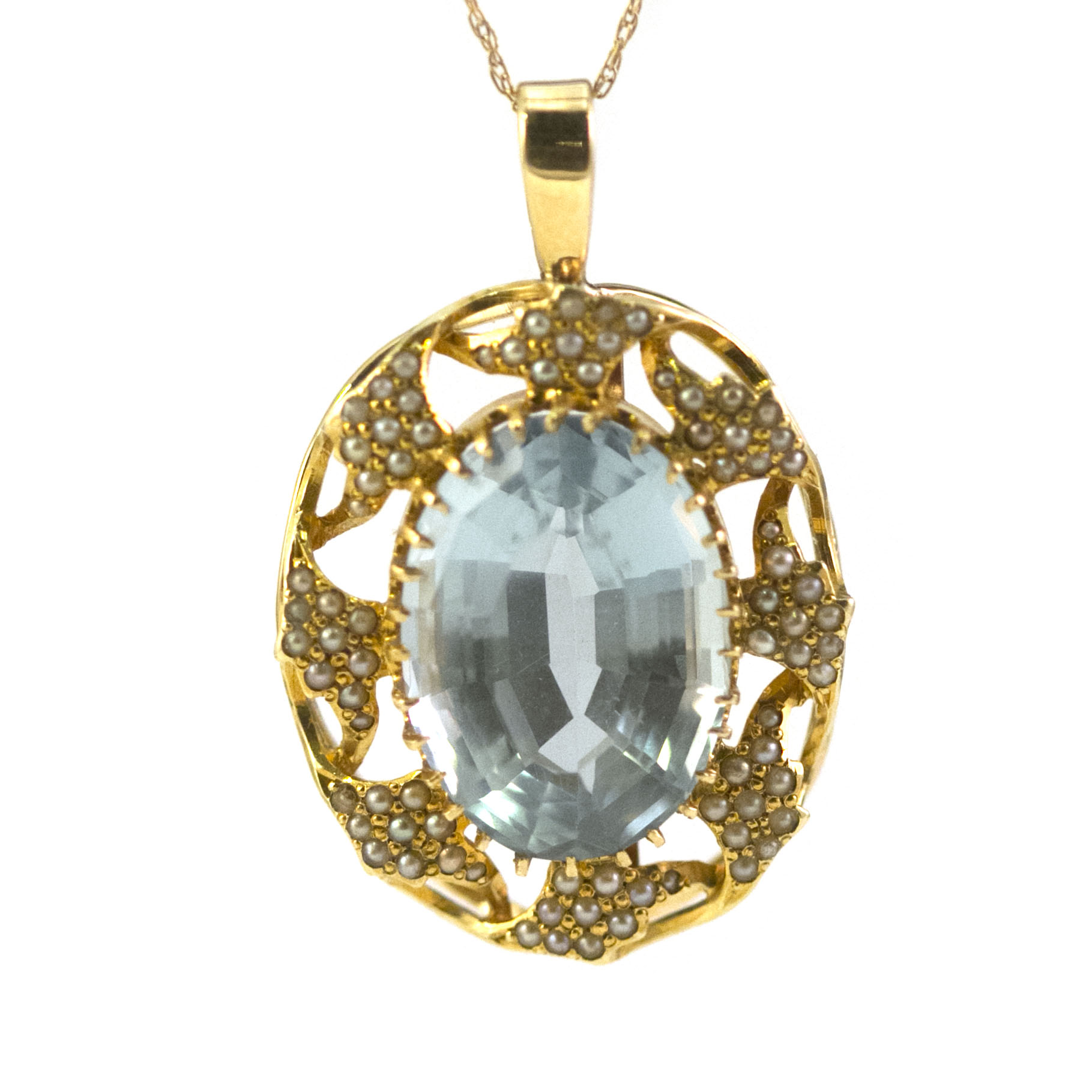 A vintage, 14K yellow gold pendant with a large fine aquamarine stone and accenting seed pearls. Represented by Haig’s of Rochester