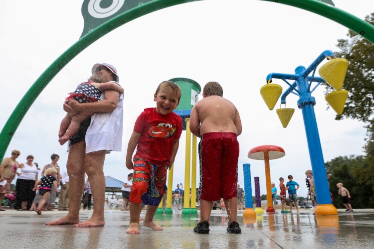 Kids play in the water at the Grand Opening Ceremony of the Greenwood Splash Park