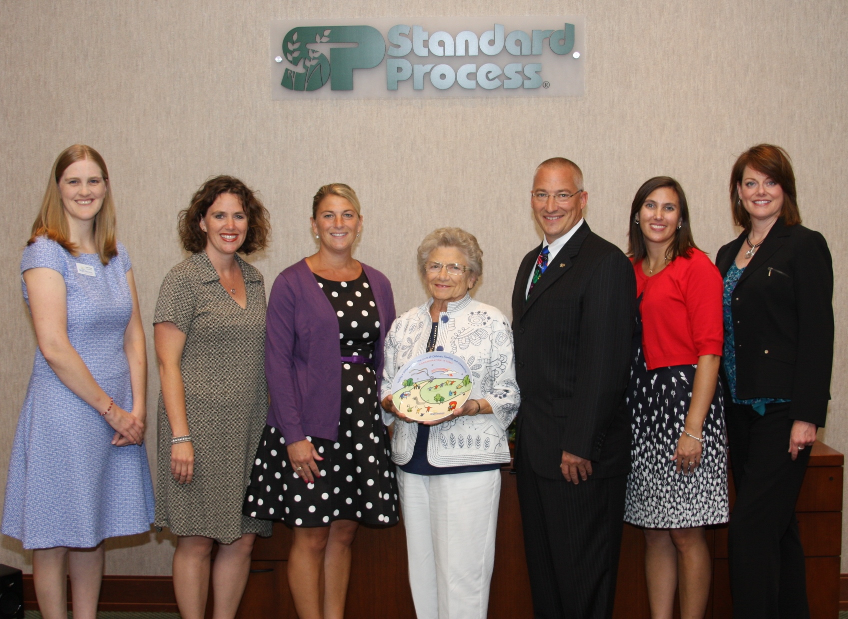 Bright Horizons representatives present a 10-year anniversary plate to Standard Process owners, (center left-right) Mary Wisniewski; Sylvia DuBois; Charles C. DuBois.