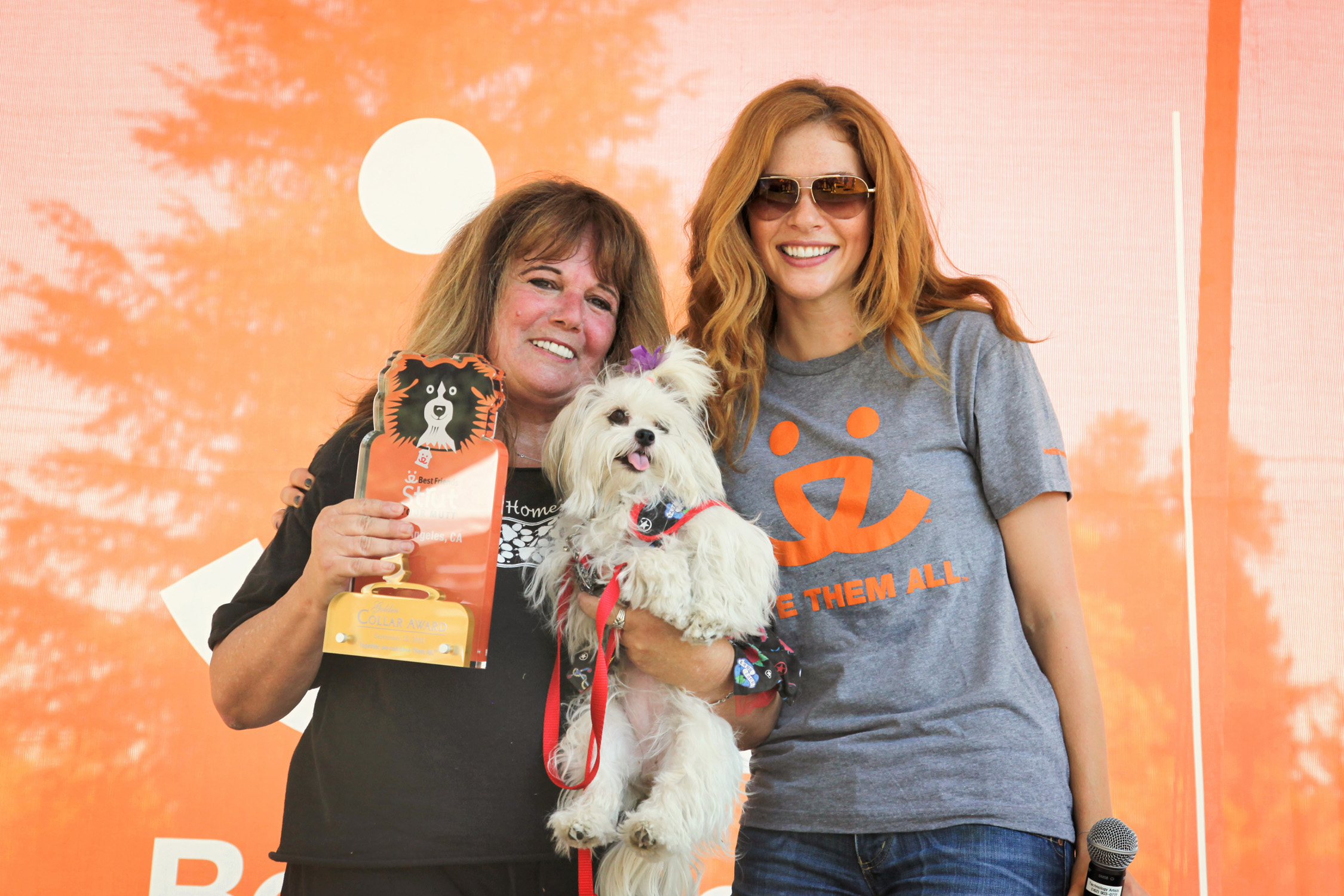 Actress Rachelle Lefevre of "Under the Dome" presents Randee Goldman of Lhasa Happy Homes with the top fundraiser award at Best Friends Animal Society's Strut Your Mutt event at Woodley Park on Sunday