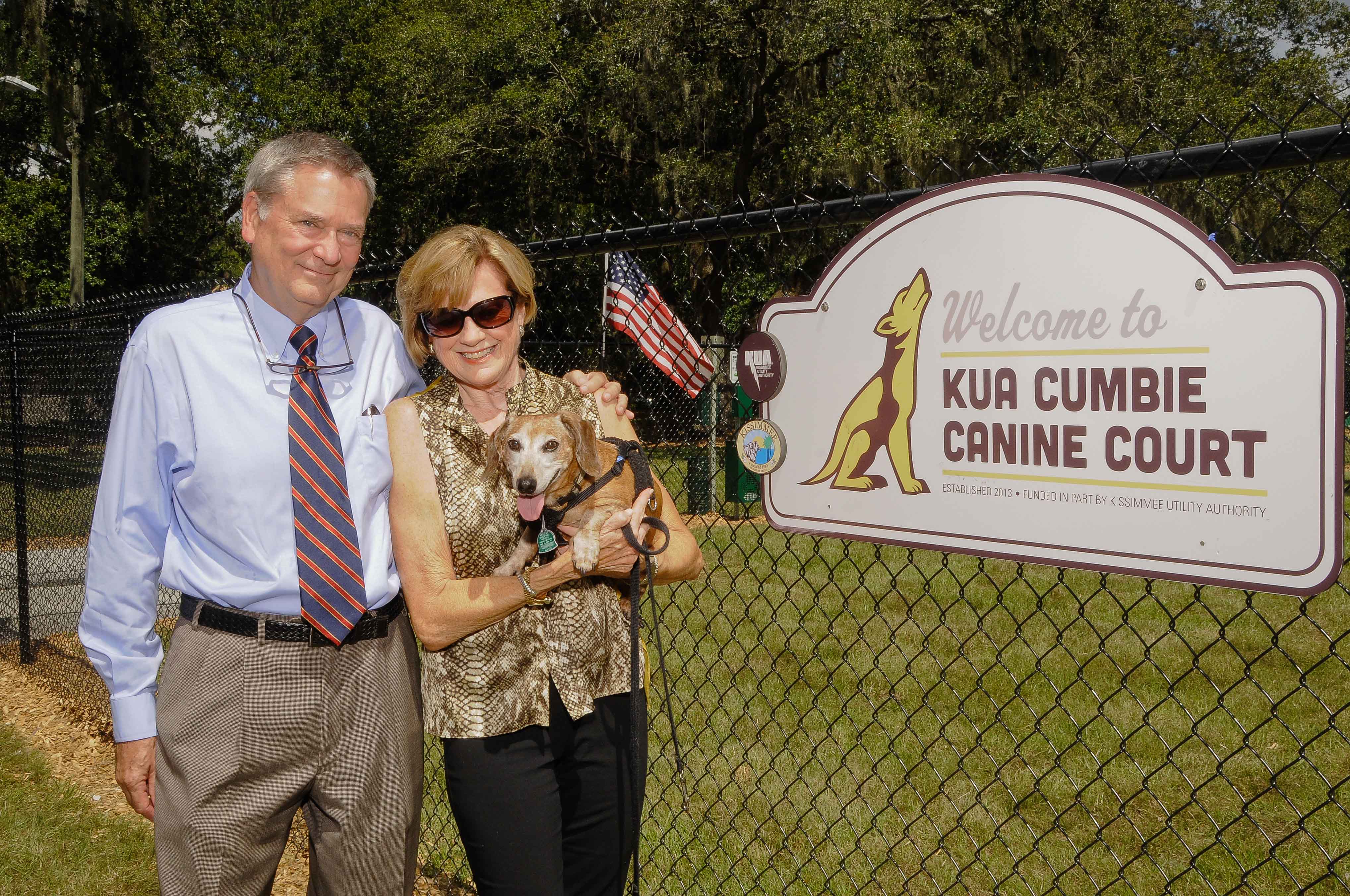 KUA board chairman Fred Cumbie (left) with wife Jo Ann and dog Sam at the entrance to the KUA Cumbie Canine Court, Kissimmee’s newest public park.