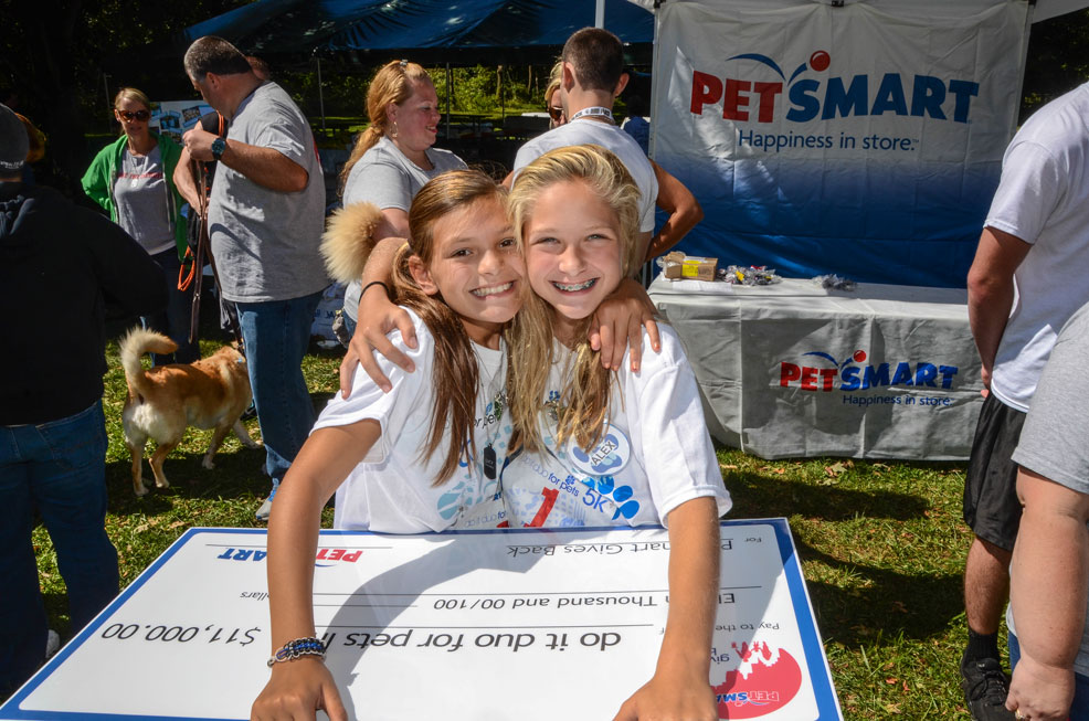 Lucy Miles (left) and Alex Dompier with a check from PetSmart