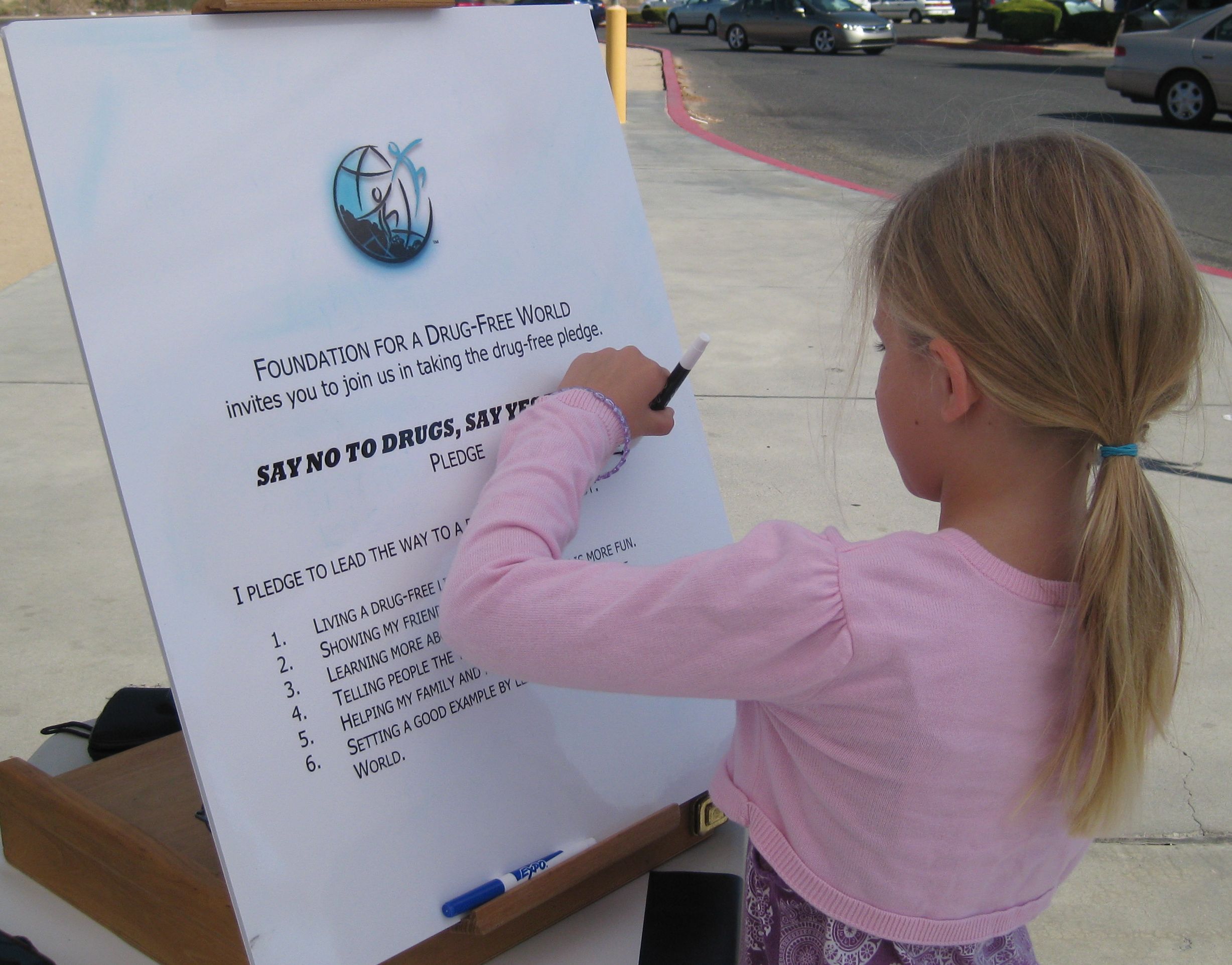 Youngster signs the drug-free pledge at a Truth About Drugs drug education booth in October 2013, in Randsburg, California.