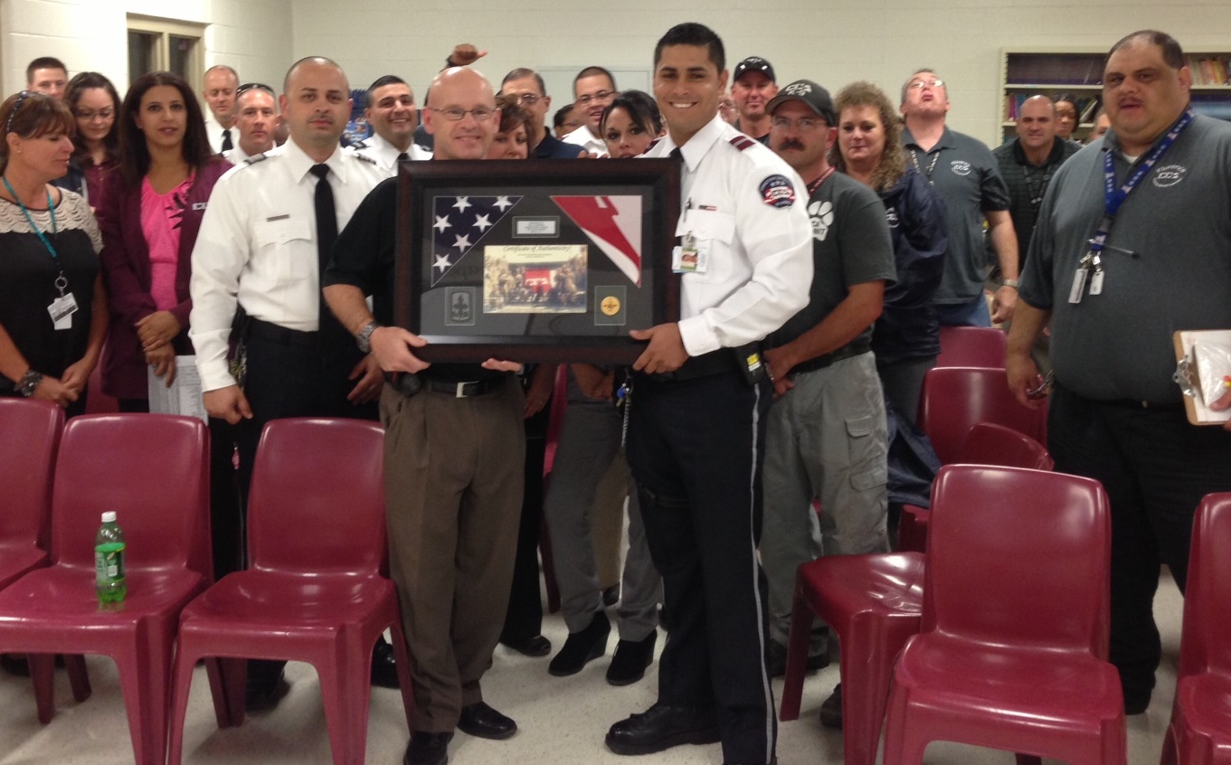 CCA Florence Correctional Counselor/US Army shares Appreciation Plaque with warden and staff.