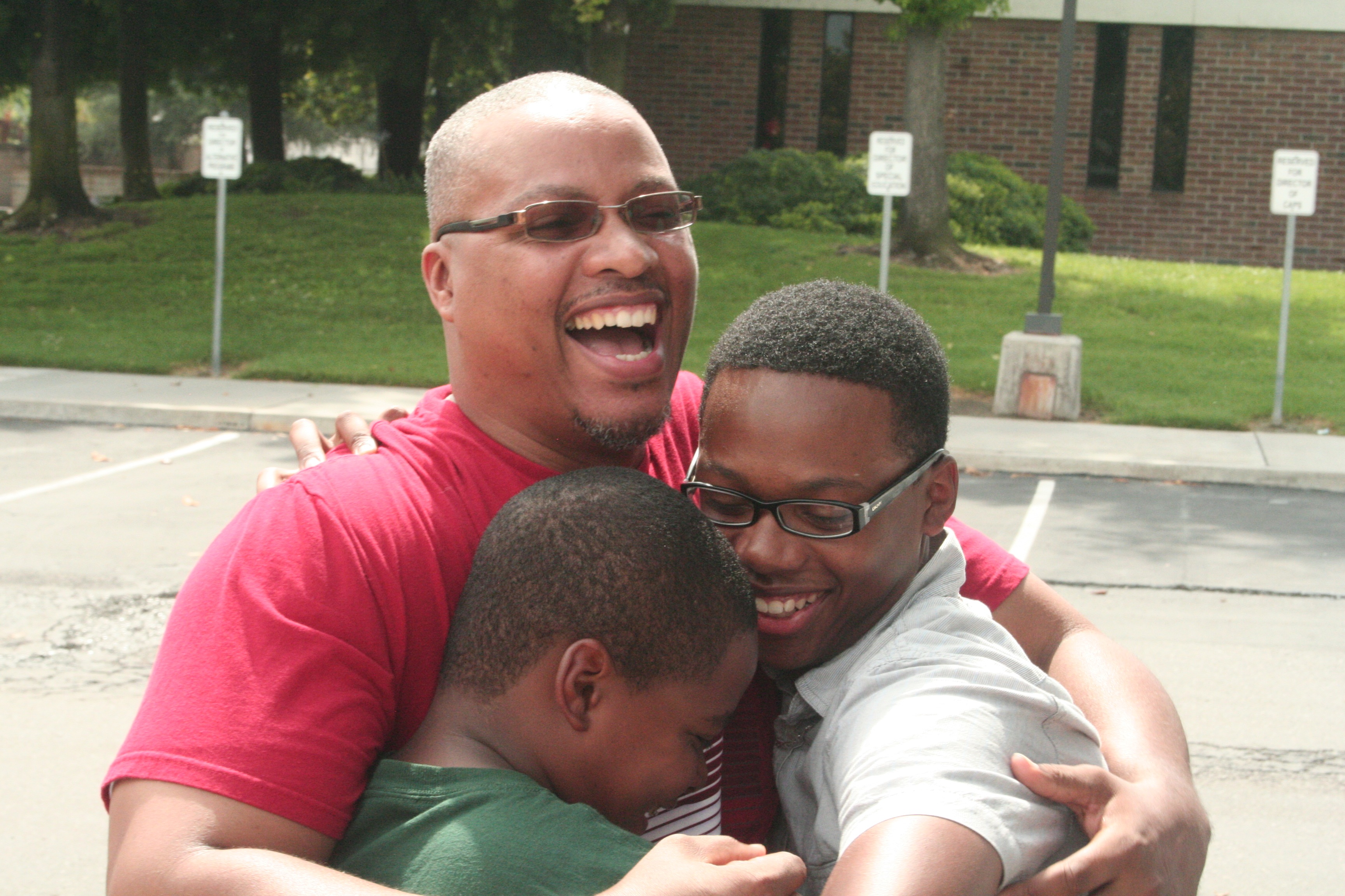 Father embraces sons after return from camp