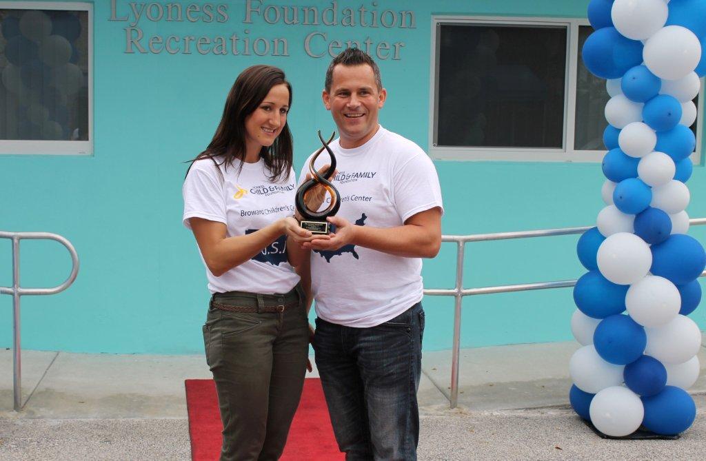 Lyoness Child and Family Foundation Director Simona Nagyova and Lyoness America CEO Mario Hoffmann receive a gift from the Broward Children's Center as an acknowledgement of their contribution.