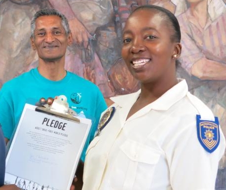 Local police officer signs a drug-free pledge November 14, 2013, at the Church of Scientology Pretoria drug prevention booth at the Twshane City Hall Substance Abuse Summit.