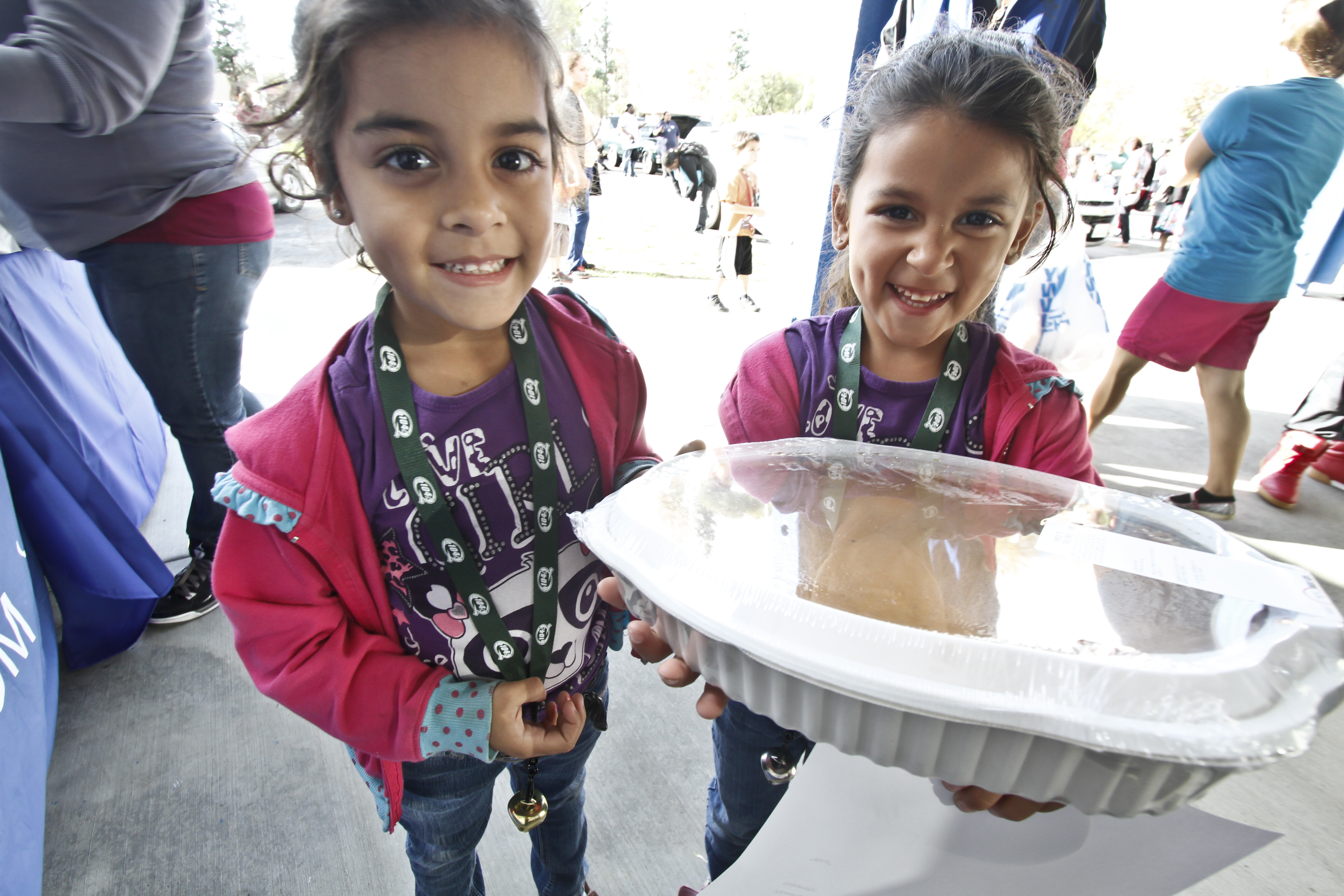 Recipients of a turkey dinner show off the large pumpkin pie they received Tuesday at Shiekh Shoes on East Highland Avenue in San Bernardino during the second annual Thanksgiving Giveback.