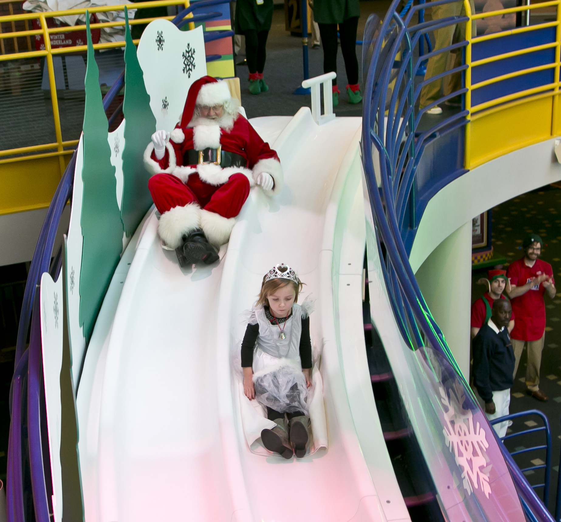 Santa slides down the Yule Slide with a little princess