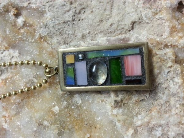 The adorable mosaic pendant will go with just about any outfit.  Colors include clear, pinks, blues, greens and more.  About 2 inches long on an 18 inch chain.